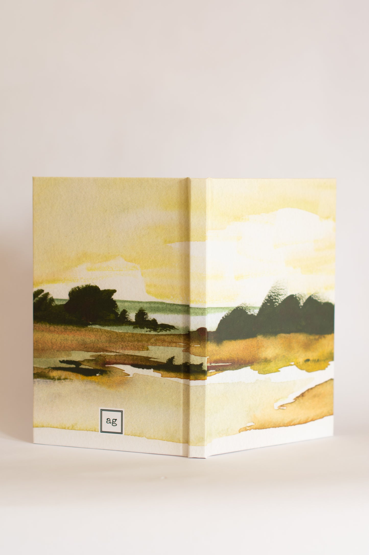 Open book with a landscape illustration on a white background