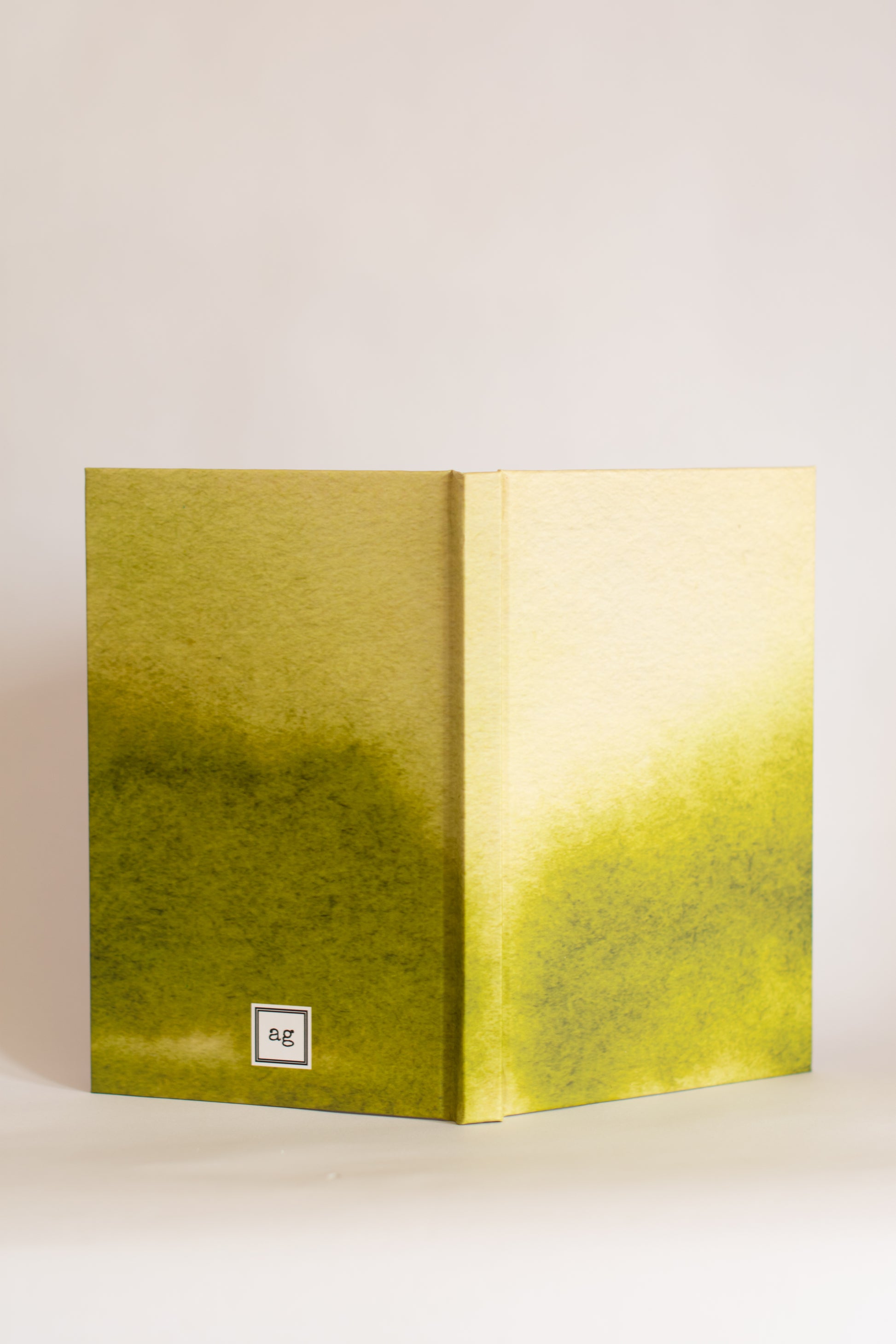 Green and yellow gradient notebook with a print shop brand logo on a light beige background