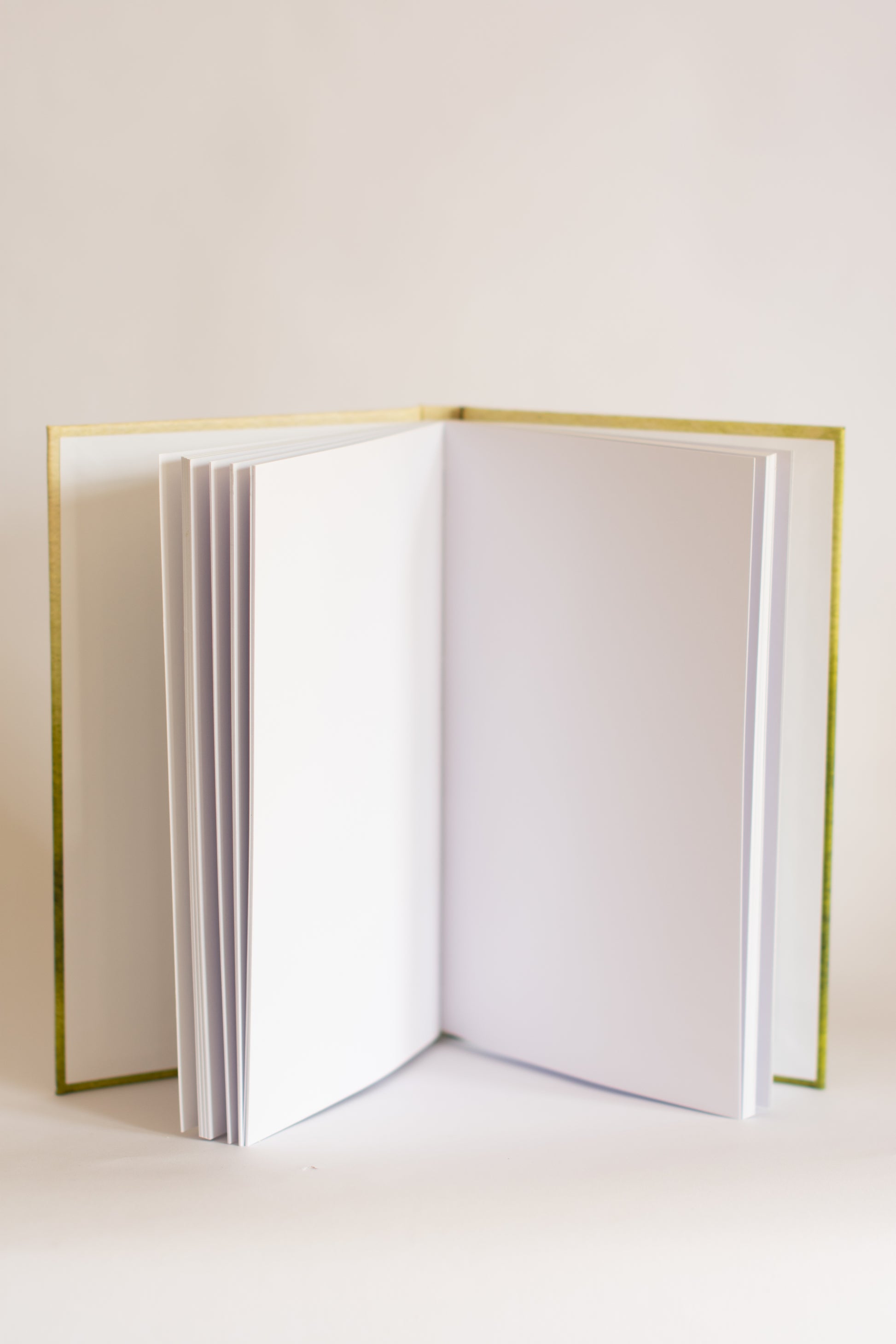 Open notebook with white pages on a light beige background