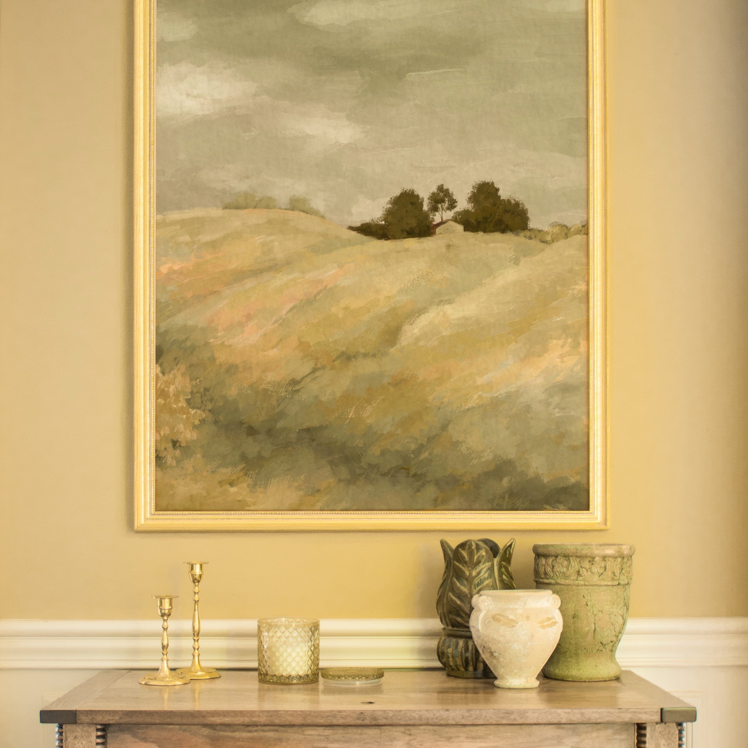 Wooden cabinet with decorative items against a wall with a framed landscape painting.
